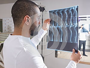 Physiotherapist Looking at X-Ray Film of Spine