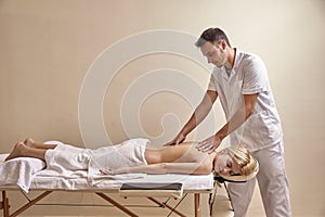 Physiotherapist massage, woman back laying on bed. full lenght shot.