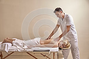 Physiotherapist massage, woman back laying on bed. full lenght shot. photo