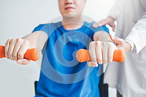 Fisioterapeuta hombre dar ejercicio pesa tratamiento acerca de brazo a hombro de atleta masculino físicamente terapia 