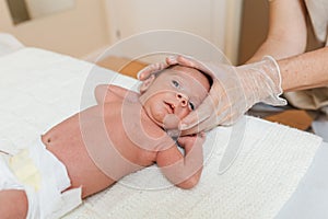 Physiotherapist performing coronal suture work on a newborn baby in a therapy center.