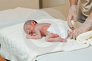 Physiotherapist performing a pro-decubitus roll over a newborn baby. photo