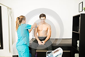 Physiotherapist Preparing Patient For Electrotherapy On Shoulder