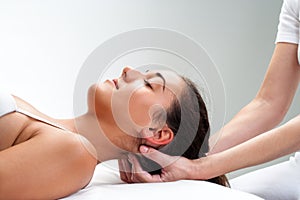 Physiotherapist pressing back of woman's head.