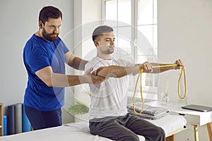 Physiotherapist& x27;s patient doing physical rehabilitation exercises with resistance band