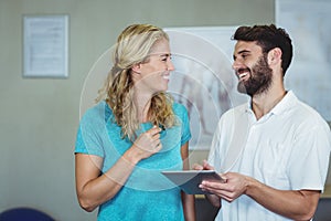 Physiotherapist showing digital tablet to woman