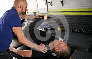 Physiotherapist stretching mature, elderly man, strength rehabilitation photo