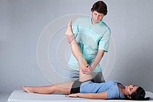 Physiotherapist stretching patient