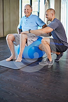 Physiotherapist, support and senior man with ball, training and elderly help for care. Men, gym and exercise for health