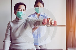 Physiotherapist training with senior women patient using dumbbell in hospital,Physical therapy concept