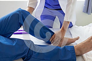 Physiotherapist treating patient at hospital Knee pain in male patient, physiotherapy concept Man
