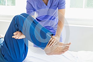 Physiotherapist treating patient at hospital Knee pain in male patient, physiotherapy concept Man