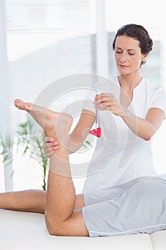 Physiotherapist using reflex hammer