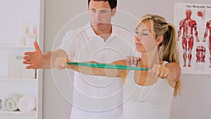 Physiotherapist using a resitance band with his patient