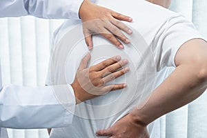 Physiotherapist working examining treating injured back of athlete male patient, Doctor doing the rehabilitation therapy pain