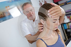 Physiotherapist working with patients neck in clinic