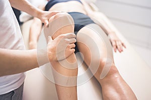 Physiotherapist working with woman giving her massage. Modern rehabilitation physiotherapy. Therapist treating injured legs of ath