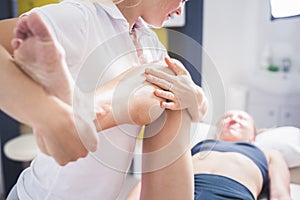 Physiotherapist working with woman giving her massage. Modern rehabilitation physiotherapy. Therapist treating injured legs of ath