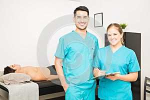 Physiotherapists With Clipboard Standing In Hospital