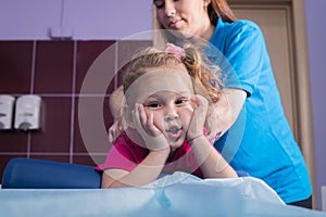 Physiotherapy with child with cerebral palsy. A little girl lays on the couch