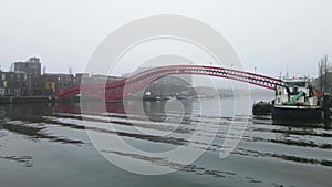 Phyton brug in Amsterdam fly underneath of a foggy grey winter day footbridge crossing art red water crossing walkway