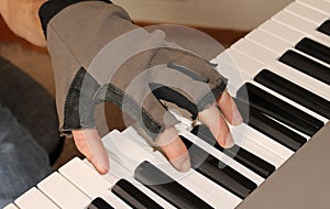 A pianist fights the chill of winter by playing with fingerless gloves.