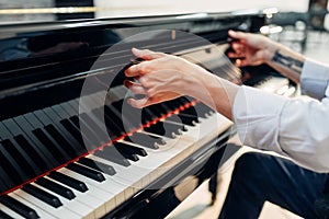 Pianist opens the keyboard lid of grand piano