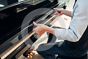 Pianist opens the keyboard lid of grand piano