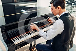 Pianist opens the keyboard lid of grand piano