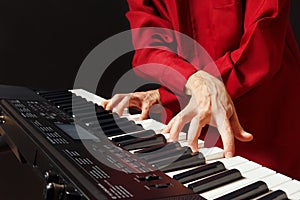 Pianist playing the digital piano on black background