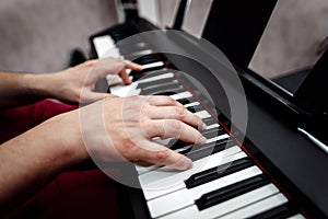 The pianist plays the piano. The pianist`s hands closely. the view from the top .