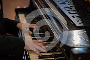 Pianist's hands in close-up while playing the piano. Piano keys during a classical music concert