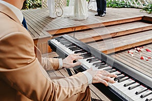 Pianist in a stylish suit plays the piano