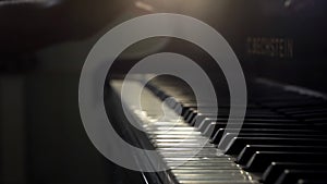 Pianists hand opens grand piano and starts playing music close up in slow motion