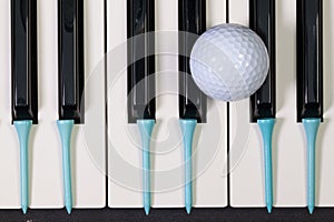 Piano keyboard and different golf balls and tees