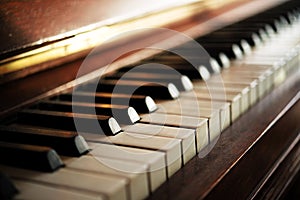 Piano keyboard of an old music instrument, close up with blurry