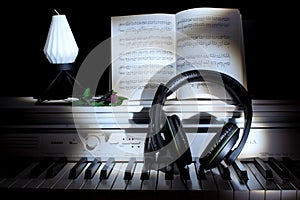 Piano keys with notes and headphones against a dark background. Music concept. Picture for wallpaper