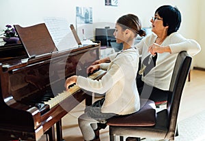 Piano lessons at music school, teacher and student.