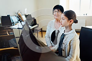 Piano lessons at music school, teacher and student.