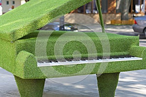 Piano made of artificial green grass, garden topiary. Selective focus, shallow depth of field
