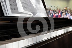 piano and notes at the concert and blurred background the audience in the hall