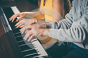 Piano players playing together four-handed