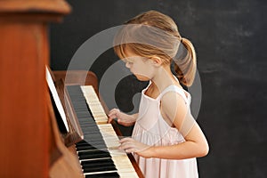 Piano, playing and kid in home for learning, practice and classical education with musical notes. Training, melody and