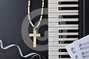 Piano with religious cross and silver bow on black table