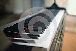 Piano side view with keys lost in the light. Piano keys side view with shallow depth of field. Piano keys monochrome. Keyboard