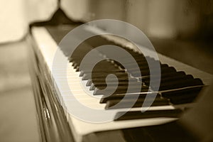 Piano side view with keys lost in the light. Piano keys side view with shallow depth of field. Piano keys monochrome. Keyboard