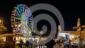 Piazza Cavour with christmas market and colored ferris wheel in the center of Ancona at night