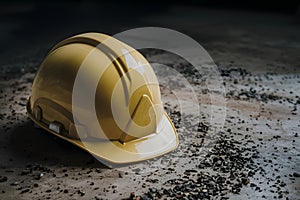 Pic Yellow safety helmet on gritty floor, highlighting workplace safety