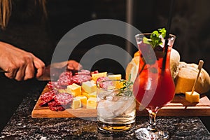 Picada table and two cocktail glasses on a black marble surface