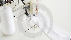 Pice of white cloth on white sewing machine, top view shot